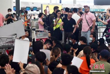 8月13日下午，大批示威者以机场手推车等堵塞香港国际机场1号客运大楼旅客登机行段及保安闸门，旅客未能经1号客运大楼前往离境大堂。中新社记者麦尚旻 摄