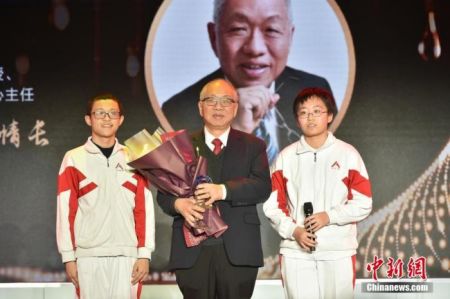 　　图为中国人民大学附属中学的两位同学为丘成桐献上奖杯，致敬杰出的华人数学家。中新社记者 翟璐 摄