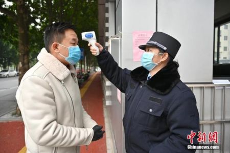 　　一名戴口罩的市民正在接受体温检测。中新社记者 俞靖 摄