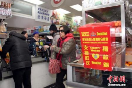 　　当地时间2月23日，顾客在加拿大多伦多唐人街一间华人超市购物时，从当地侨团为支援中国内地抗击疫情而在店内设置的捐款箱旁走过。超市负责人表示，新型冠状病毒疫情发生以来，华人商区生意受到明显冲击，随着商家、政府等多方努力、宣传，消减民众恐慌情绪，目前超市生意逐渐有所好转。中新社记者 余瑞冬 摄