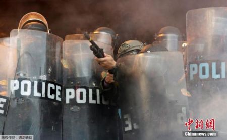 　　当地时间5月30日，美国迈阿密警察局附近的示威活动中，一名警察向示威者发射橡皮子弹。
