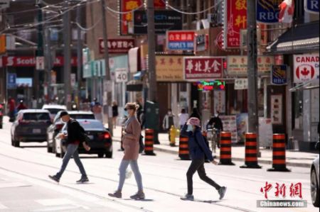 　　资料图：佩戴着口罩的行人穿行在加拿大多伦多中区唐人街。中新社记者 余瑞冬 摄