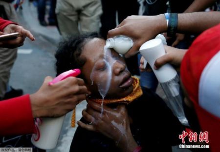 　　资料图：当地时间5月31日，美国华盛顿白宫附近的拉斐特公园的抗议活动中，抗议者们为受胡椒喷雾剂影响的妇女清洗眼部。
