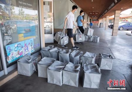 　　资料图：美国硅谷腹地“盐语”厨房的送餐员将打包好的保温袋搬到各自的车上，再送往附近的客户手中。 中新社记者 刘关关 摄