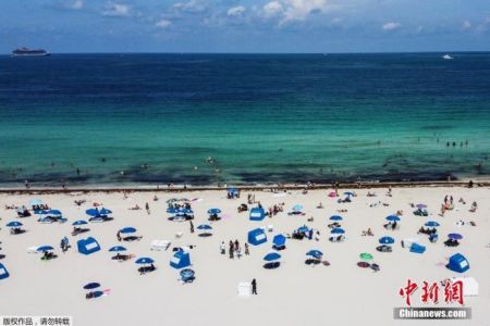 　　资料图：当地时间6月10日，美国佛罗里达州迈阿密海滩关闭近三个月后首次开放，工作人员提醒游客保持社交距离的前提下享受阳光沙滩。