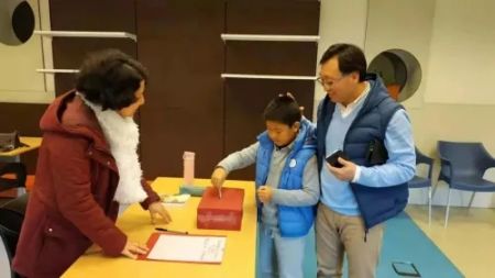 　　华校家长与孩子一起在学校捐赠。中国华文教育基金会 供图