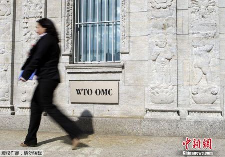 　资料图：一女子在位于日内瓦的世贸组织大楼入口处前走过。