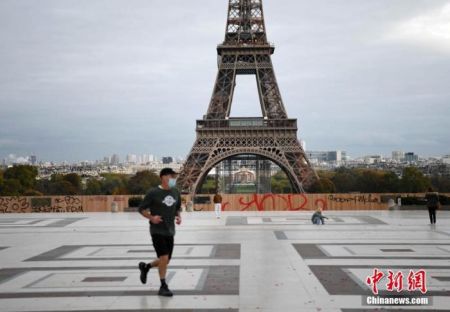 　　当地时间10月30日，法国进入第二次全国“封城”，以应对新冠肺炎疫情恶化。图为当天巴黎埃菲尔铁塔附近，一名体育锻炼者在跑步。官方准许人们进行适当的体育锻炼，有时间和地点限制。 中新社记者 李洋 摄
