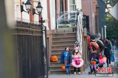 　当地时间10月31日，美国传统节日万圣节前夜，纽约市布鲁克林区穿着万圣节装束的孩童到各处要糖。 中新社记者 廖攀 摄