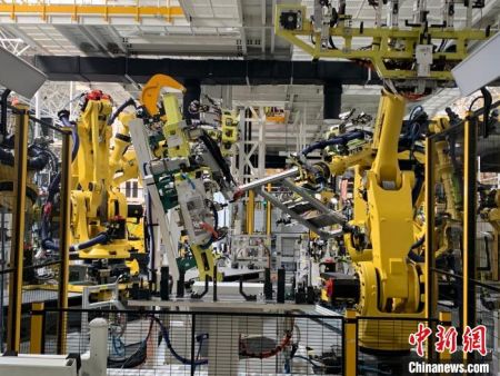 　16日，在位于江西上饶的一家新能源电动汽车公司的智慧工厂内，412台宛如“变形金刚”的机器人正同时作业。　李韵涵　摄