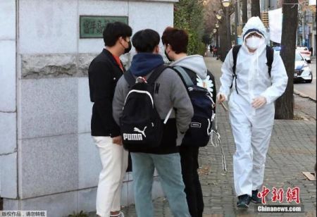 据报道，由于新冠疫情持续反弹，韩国政府6日宣布将从8日零时起再次上调全国防疫级别。图为韩国街头一名“全副武装”的行人。