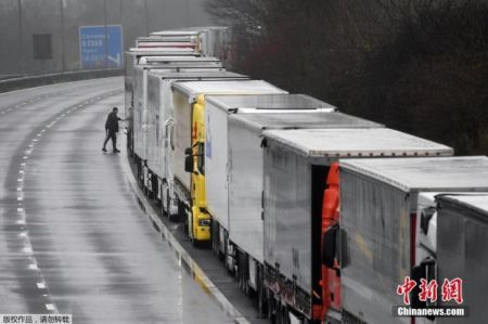 　　当地时间12月21日，在英国宣布发现变异病毒后，欧盟多国对英国实施交通封锁。英国阿什福德附近的M20高速公路上，长途货运卡车无法出境在路边排起长龙，首尾相接如同一列停靠在路边的火车。