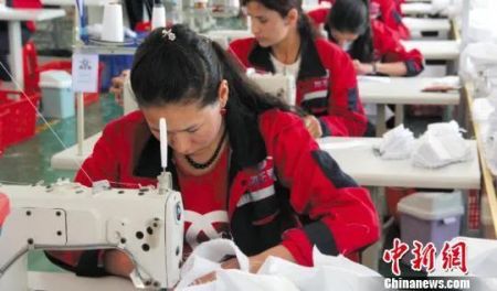 　资料图：在新疆喀什地区塔什库尔干塔吉克自治县纺织工业园区服装厂内，经过技术培训的工人们熟练地缝制外裤。(图文无关) 朱景朝 摄