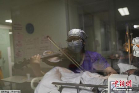 　当地时间2020年7月9日，智利圣地亚哥，埃尔皮诺医院护士Damaris Silva为重症监护室内新冠肺炎患者演奏小提琴。
