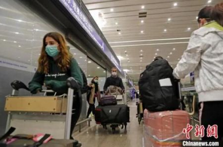 外籍入境人员推着行李前往上海16个区驻机场分流点。　殷立勤 摄