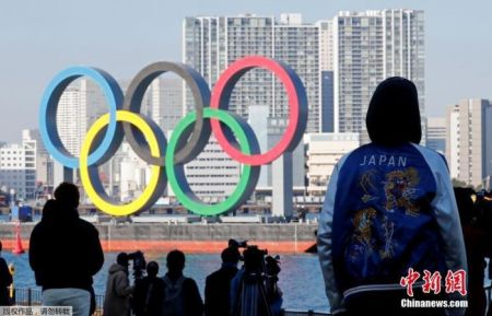 　　资料图：日本东京民众眺望东京湾上的奥运五环标志。