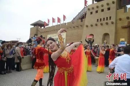 　资料图：吐鲁番交河驿·坎儿井源景区献上舞蹈表演，欢迎团队游客。　苟继鹏 摄